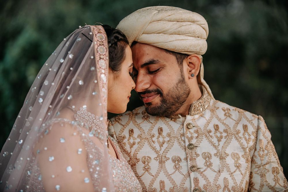 A couple in traditional Pakistani wedding attire share an intimate moment during their celebration.