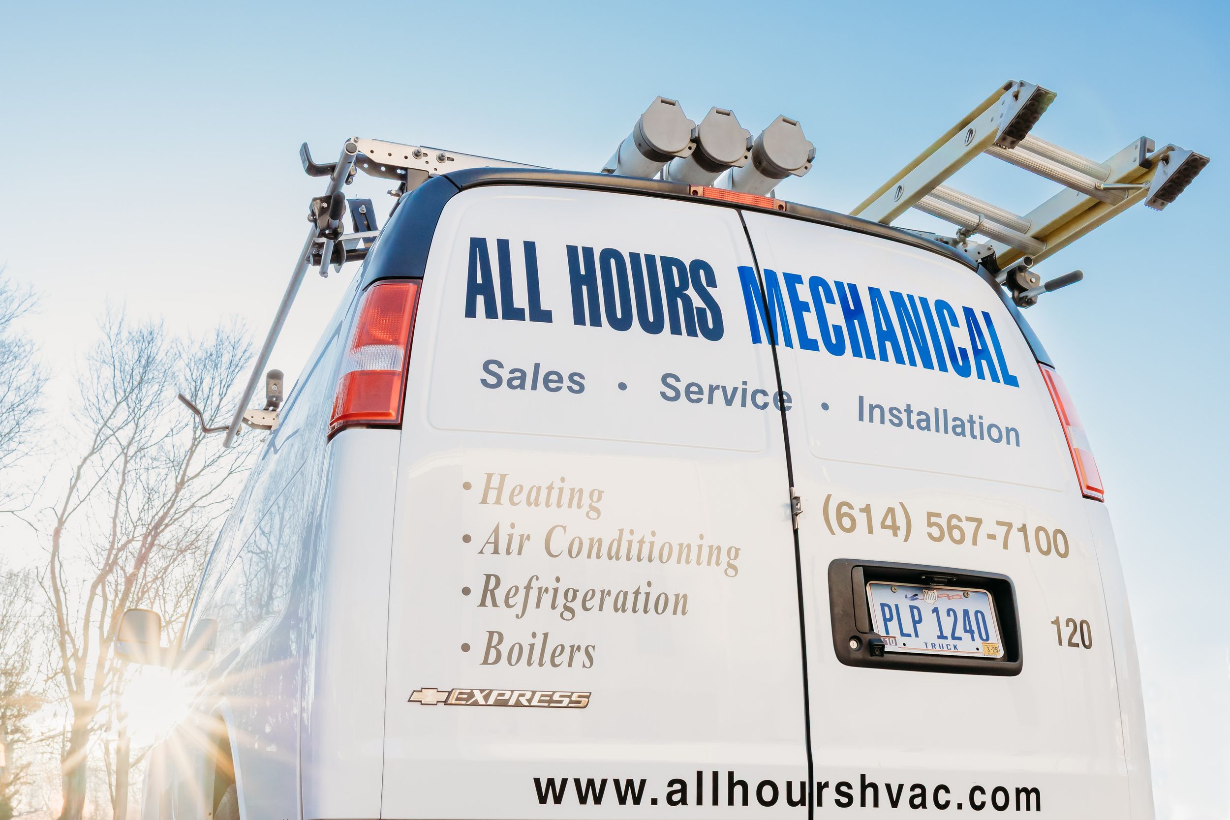 An HVAC service van with 'All Hours Mechanical' company branding and service details displayed on its side panel.