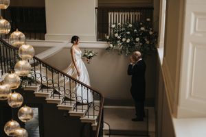 Bride descends down elegant staircase towards her father in a reception hall at Saltmarshe Hall - taken by Grimsby photographer.