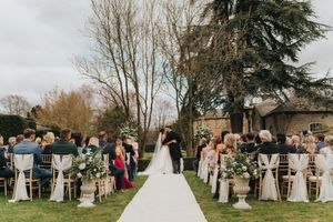 Wedding guests gather outdoors in celebration at a scenic garden venue on a cloudy autumn day at Saltmarshe Hall - by Grimsby photographers.