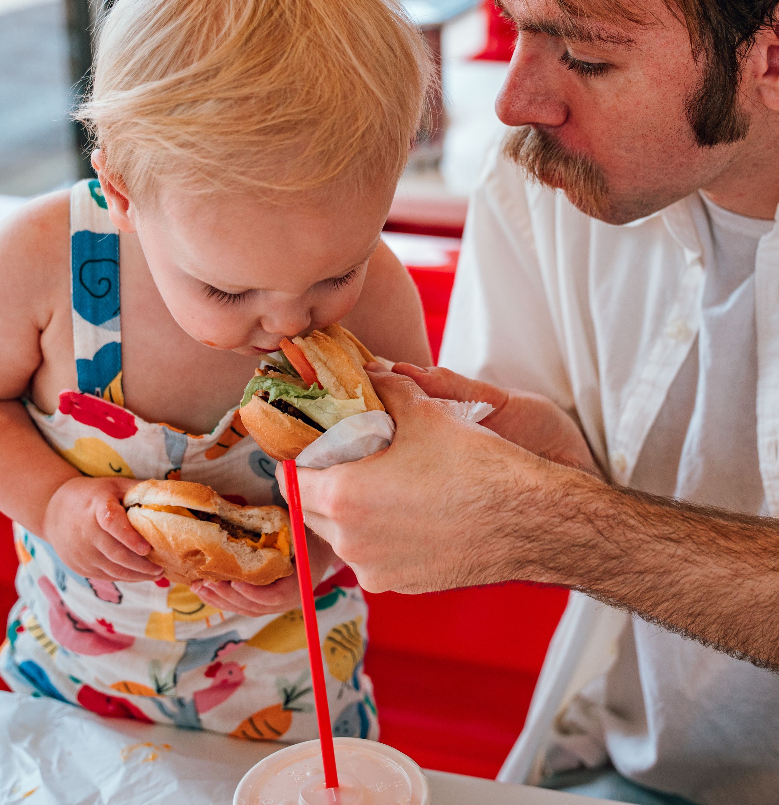 a toddler eats a vegan burger from Face Plant in Portland OR