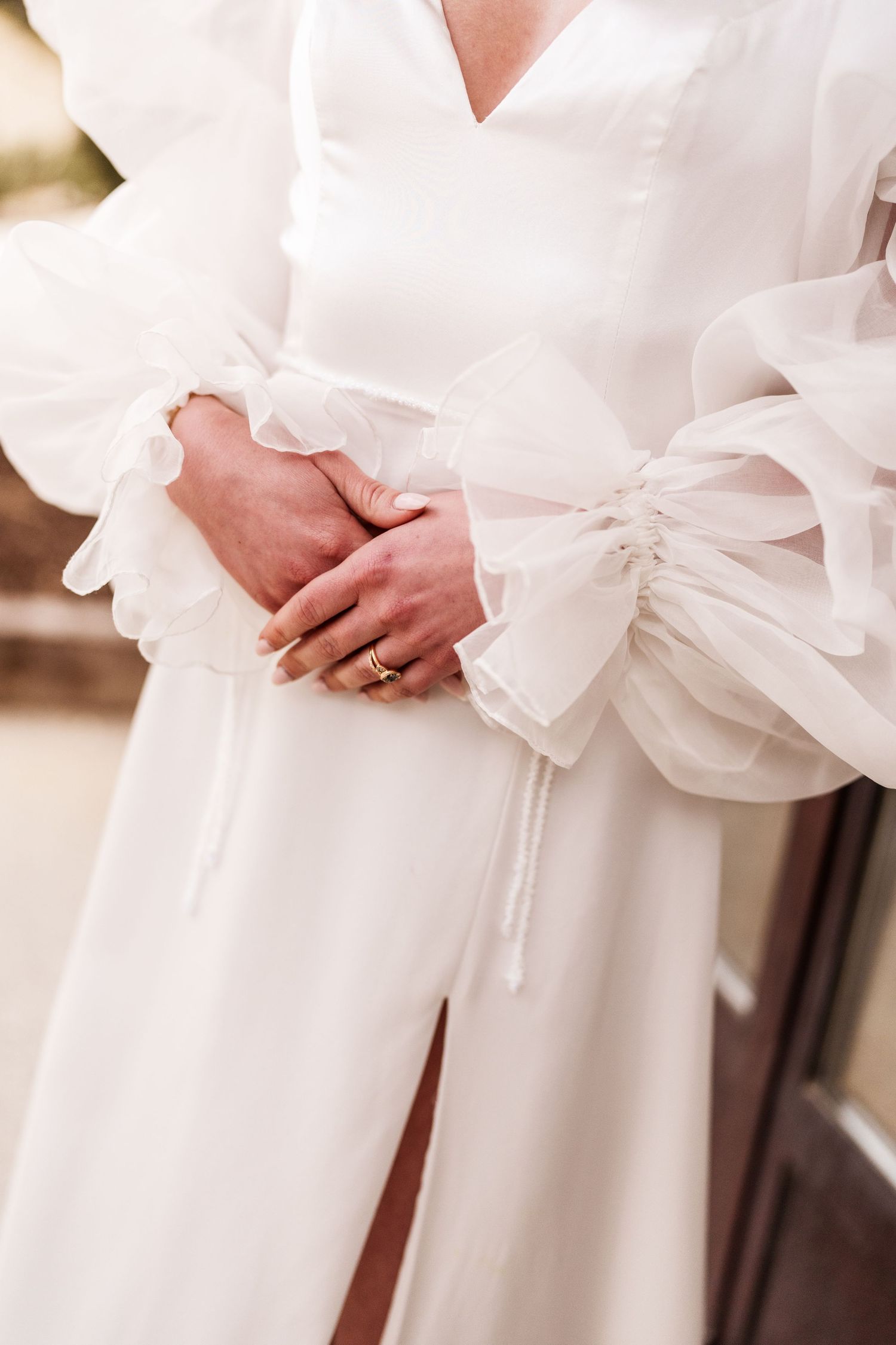 Close-up detail of a wedding dress showing puffy sleeves and delicate waist tie.