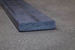 A series of dark rubberized gym floor mats or tiles shown at various angles on a concrete surface.