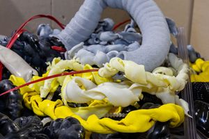 White and yellow robotic arms conducting precision assembly work in an industrial automation setting.
