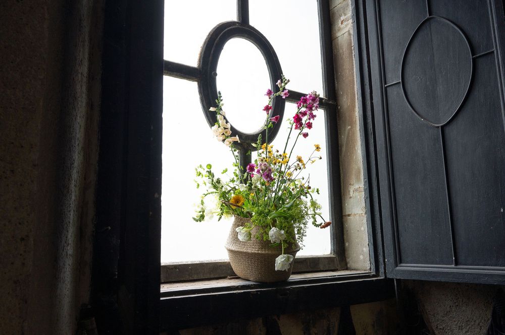 Maceta con flores en ventana del palacio