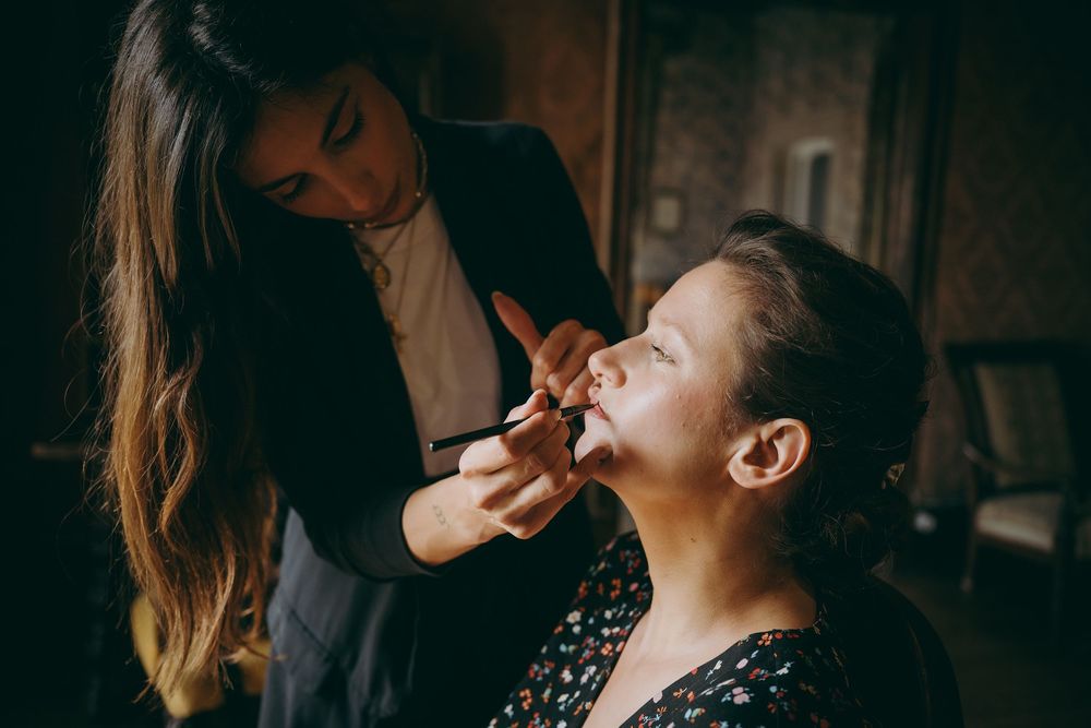 Maquilladora aplicando labial a la novia