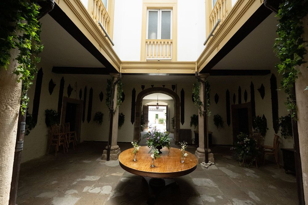 Soportales de piedra con mesas en el patio del palacio