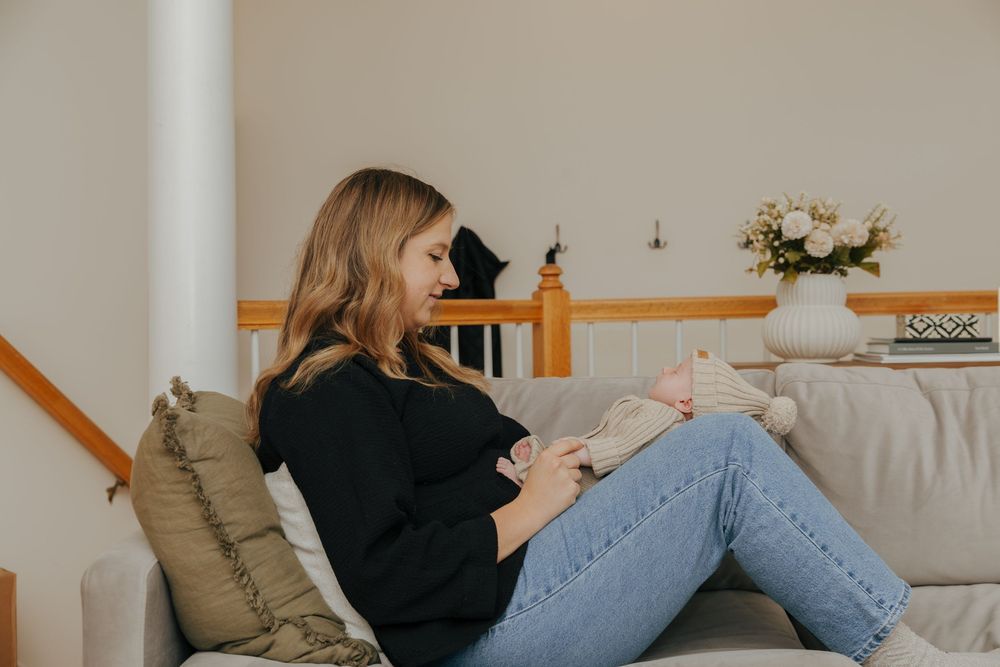 People lounging comfortably on a couch in a light-filled room with casual attire.