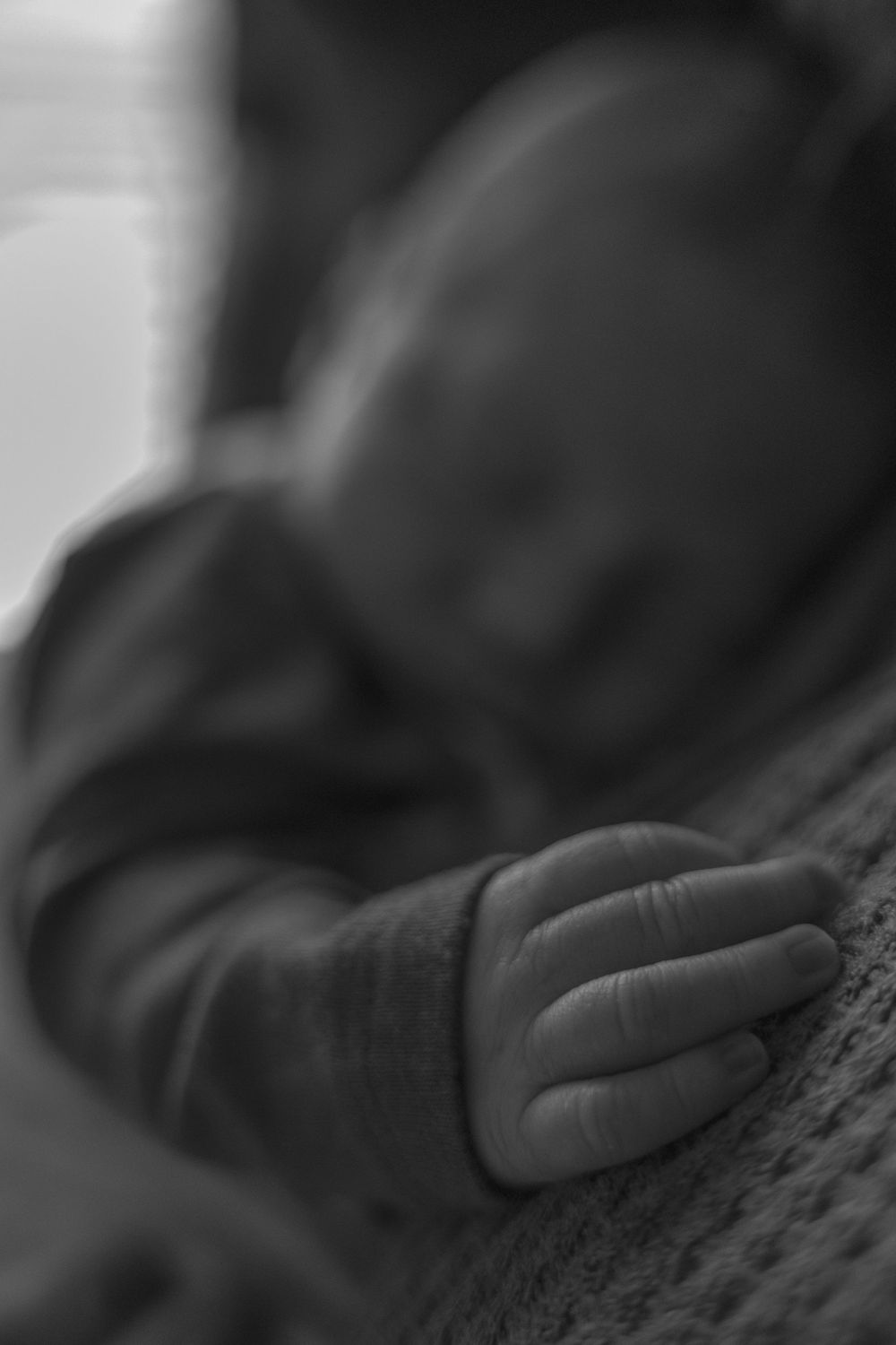 Black and white close-up of hands touching textured fabric.