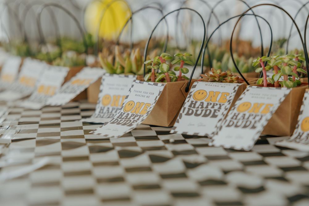 Wedding favor bags with decorative tags arranged on a checkered surface.