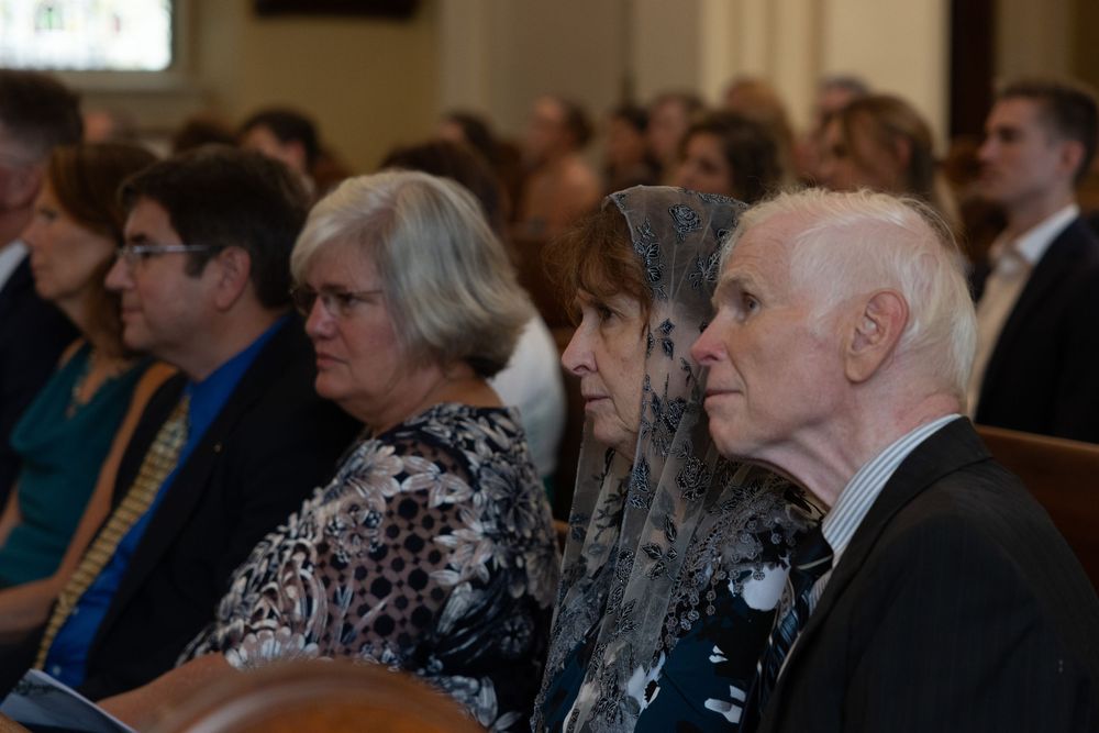 Attendees sitting in rows at a formal event or ceremony in an indoor venue.