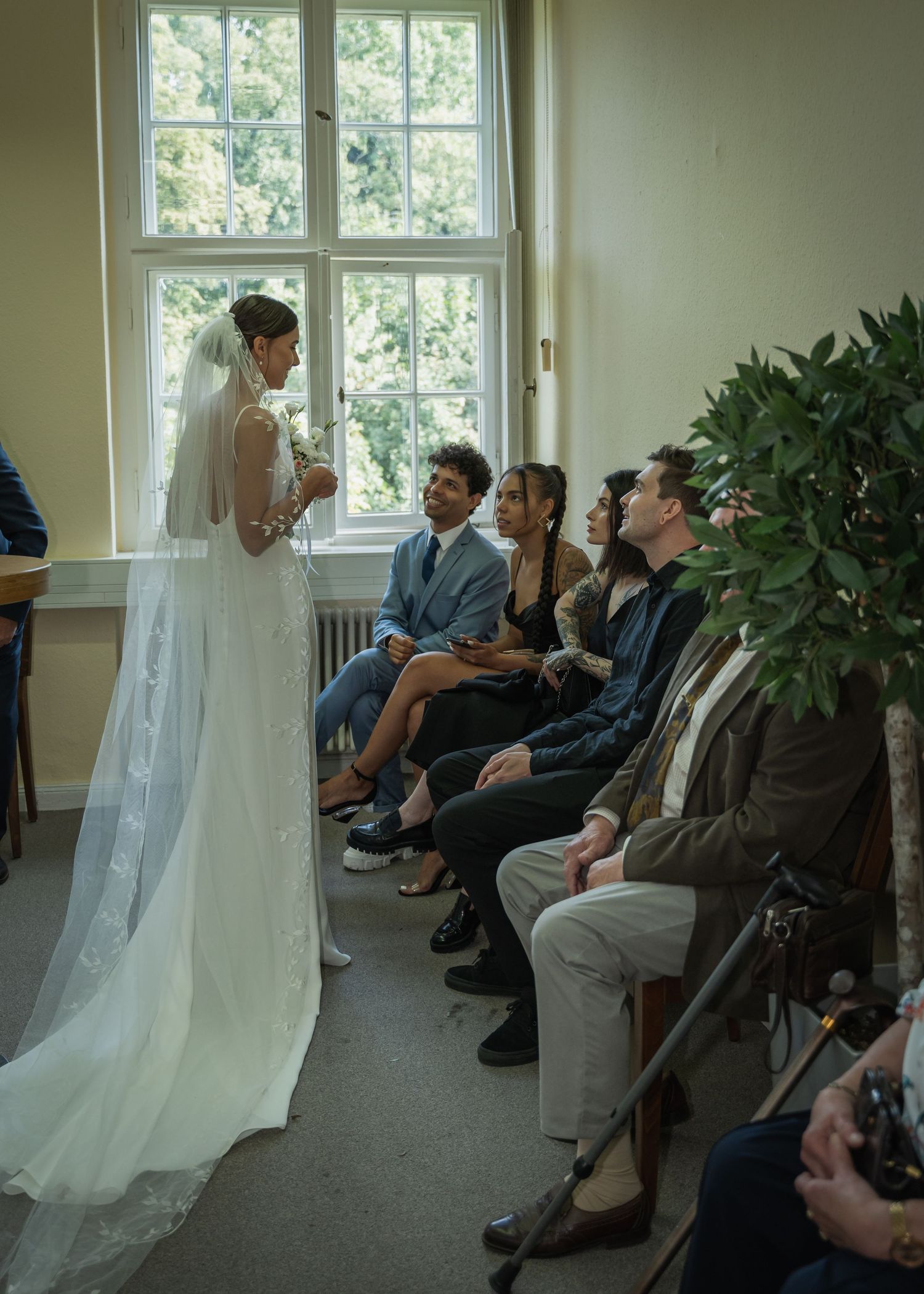 Hochzeitsfotograf Standesamt Treptow-Köpenick Berlin – Braut geht durch den Saal mit Schleier und Gästen