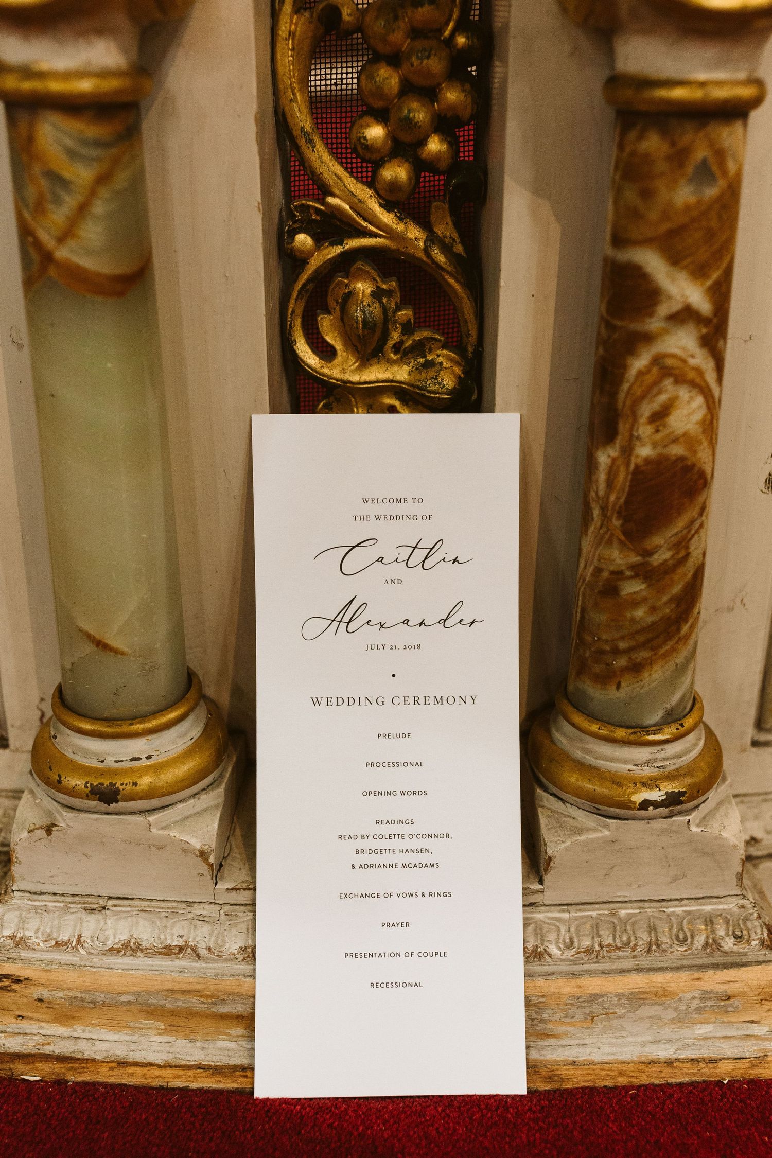 Elegant wedding ceremony details with ornate gold columns and classic invitation stationery.