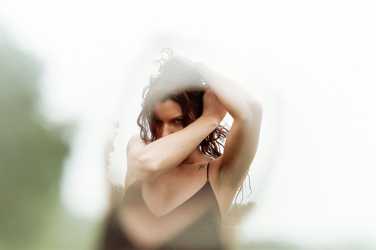 A blurry artistic photograph showing hands holding a vintage camera with a soft bokeh background effect.