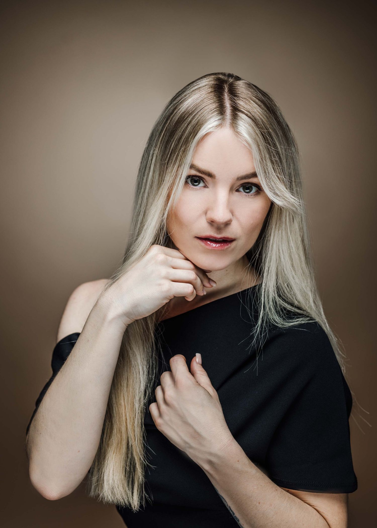 A series of artistic portraits in black clothing against a neutral background with dramatic lighting and poses.
