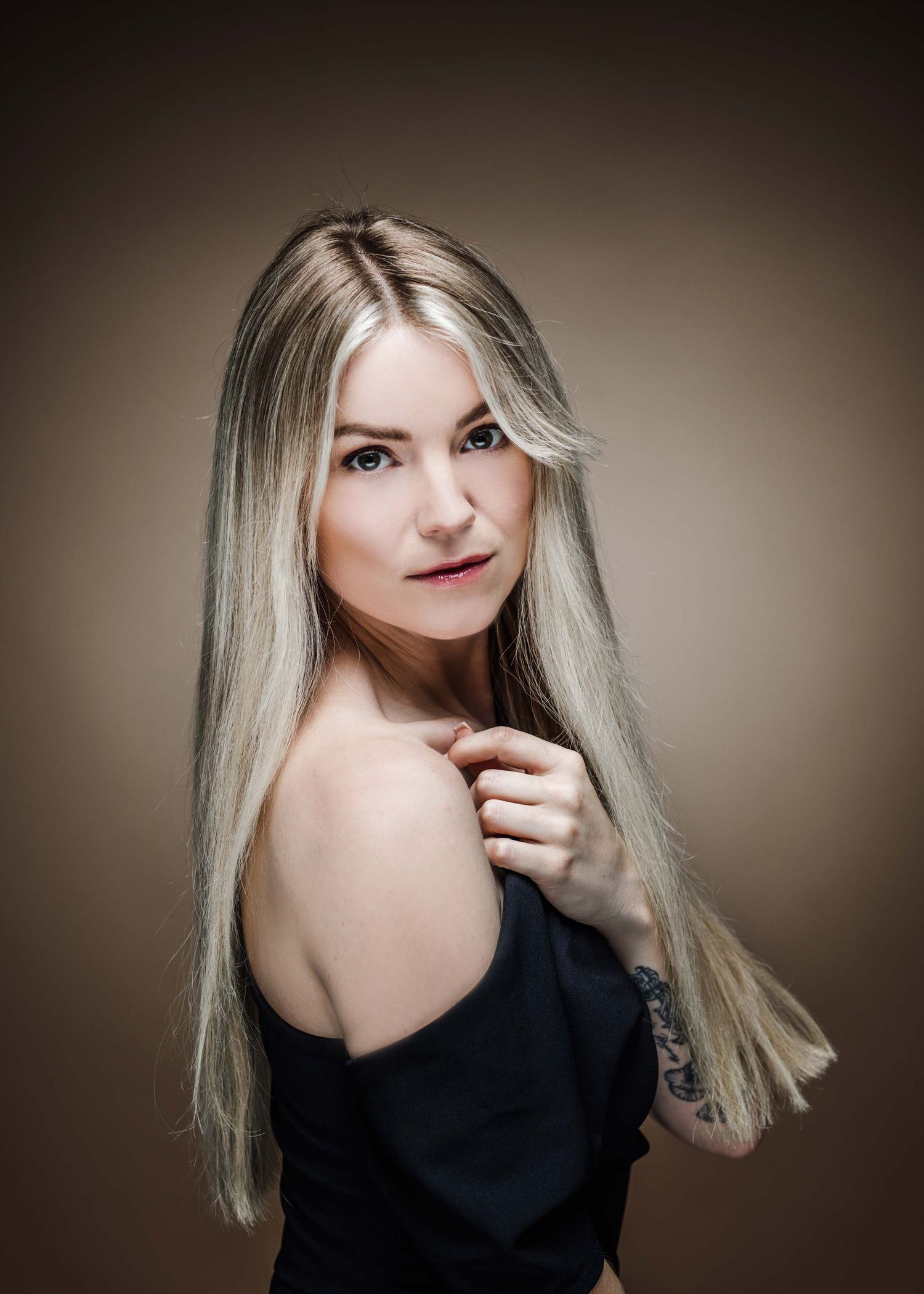 Elegant studio portraits featuring blonde hair and a black top with dramatic lighting and poses.