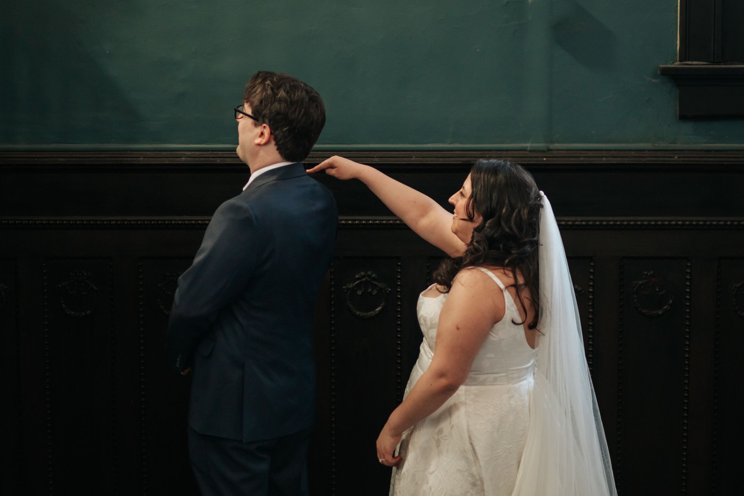 A couple shares a romantic dance during their wedding reception in a dimly lit venue.
