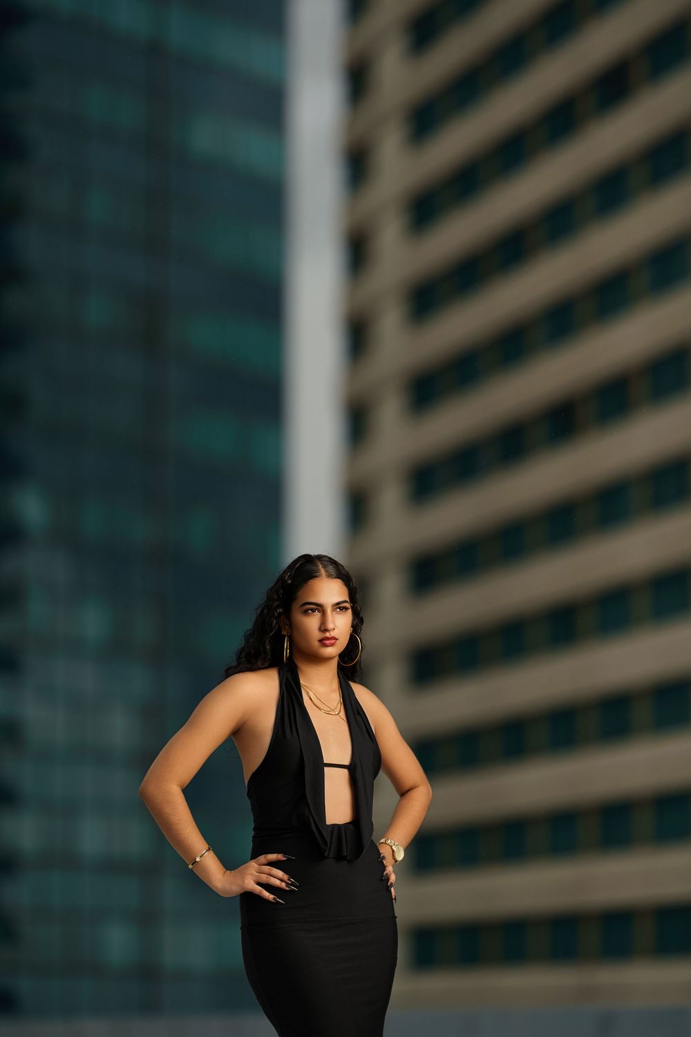 Dramatic fashion photography against modern architecture with moody lighting and urban backdrop.