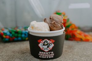 Ice cream scoops in branded black bowls with colorful candy toppings.