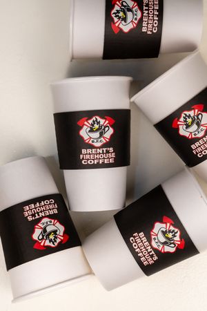 Multiple coffee cup sleeves with Firehouse Coffee branding arranged in a pattern.