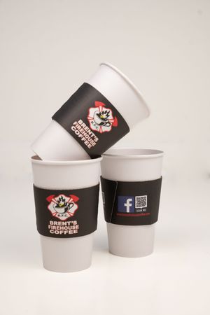 White and brown branded coffee cups arranged in a minimalist product photography setup.