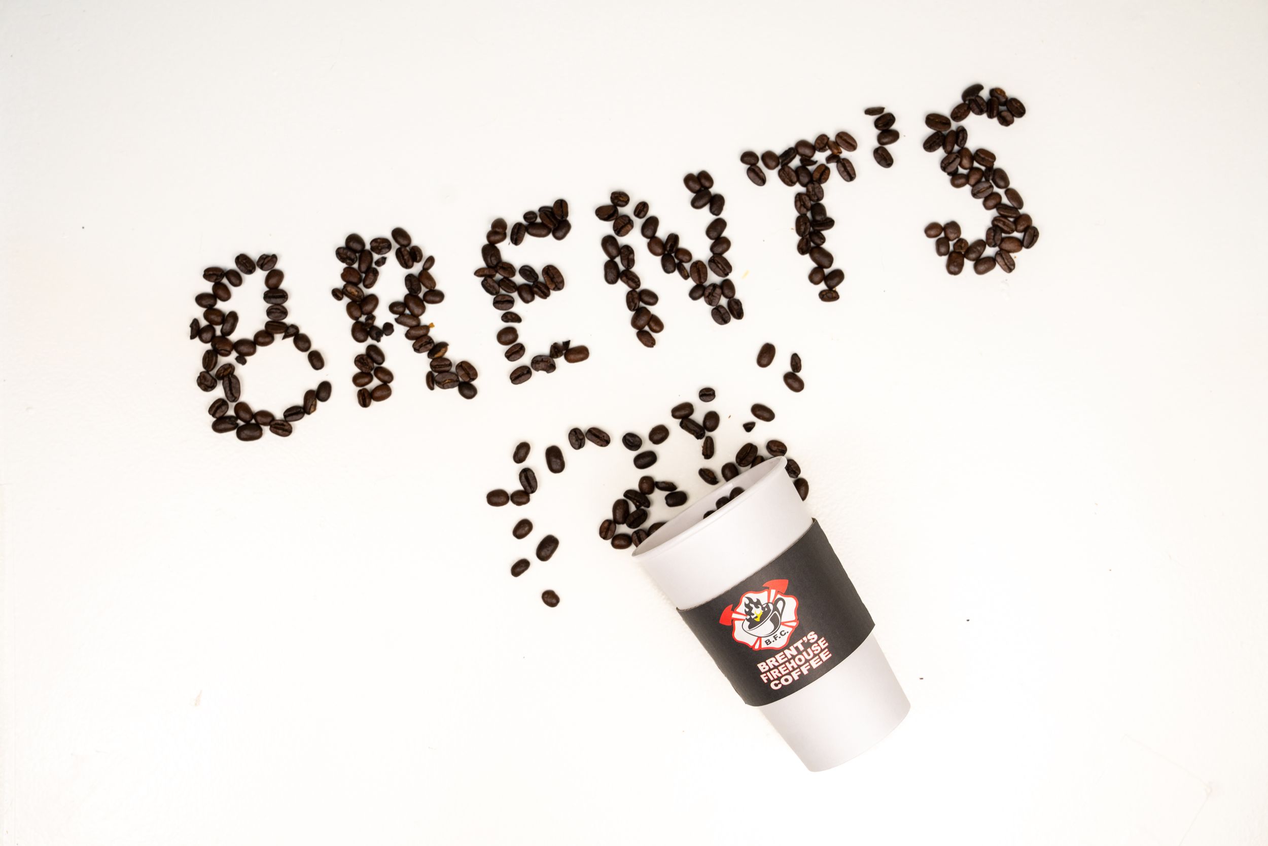 Coffee beans arranged to spell text against white background.