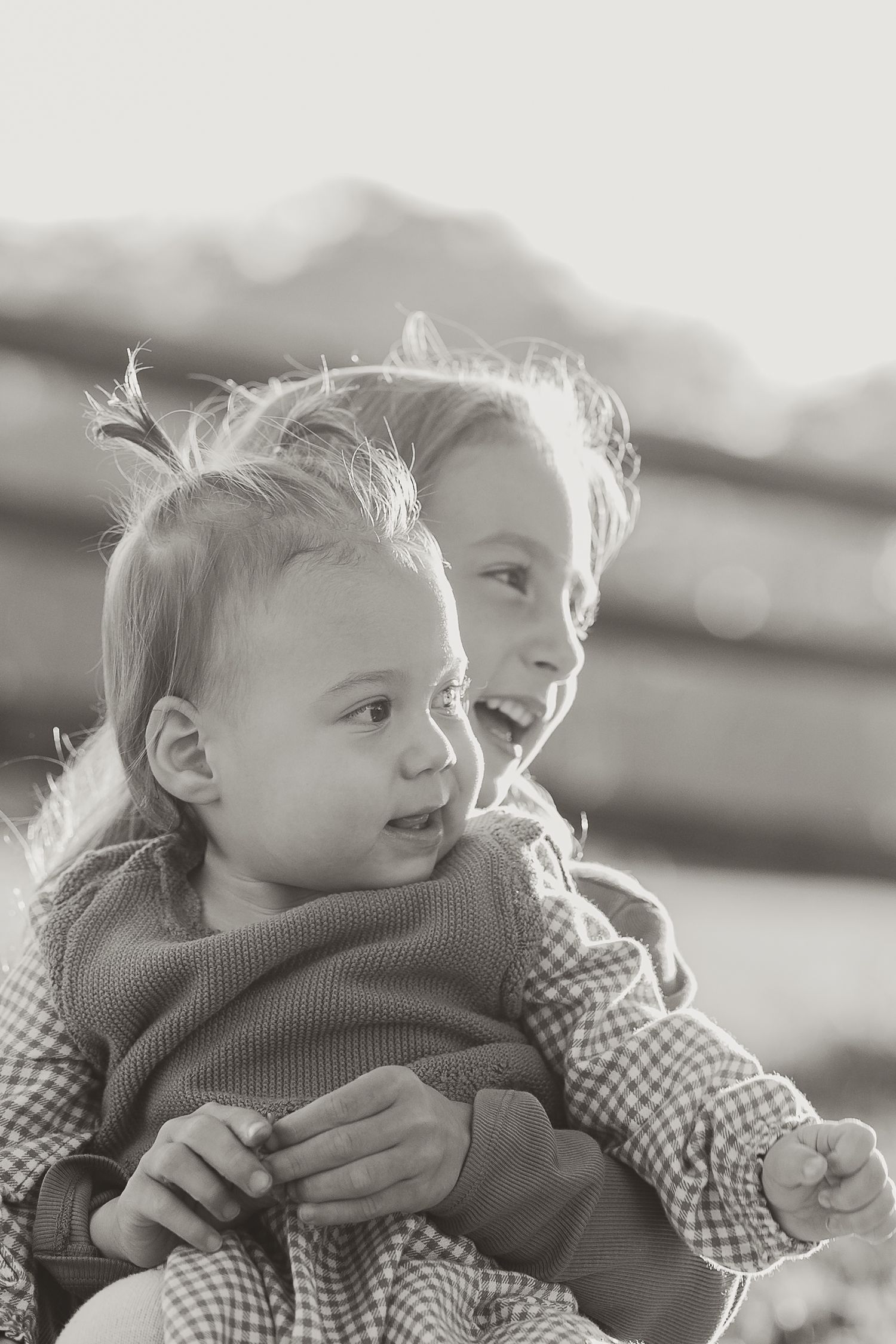 Black and white portraits of child and parent in natural backlit setting.