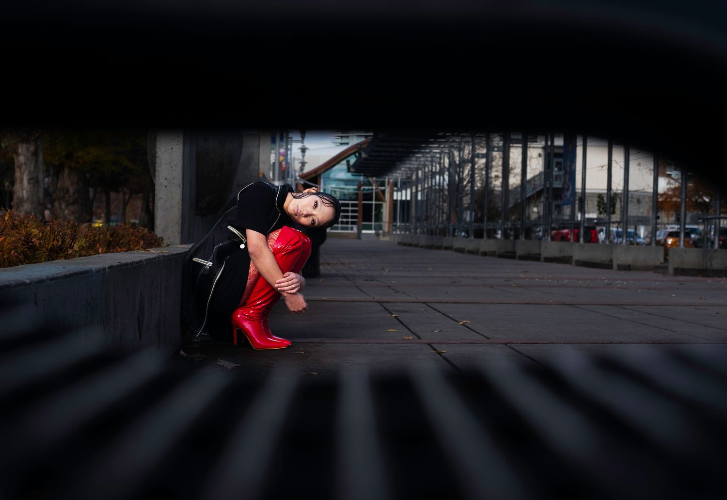 Artistic urban parkour sequence showing person in red against dark architectural background.