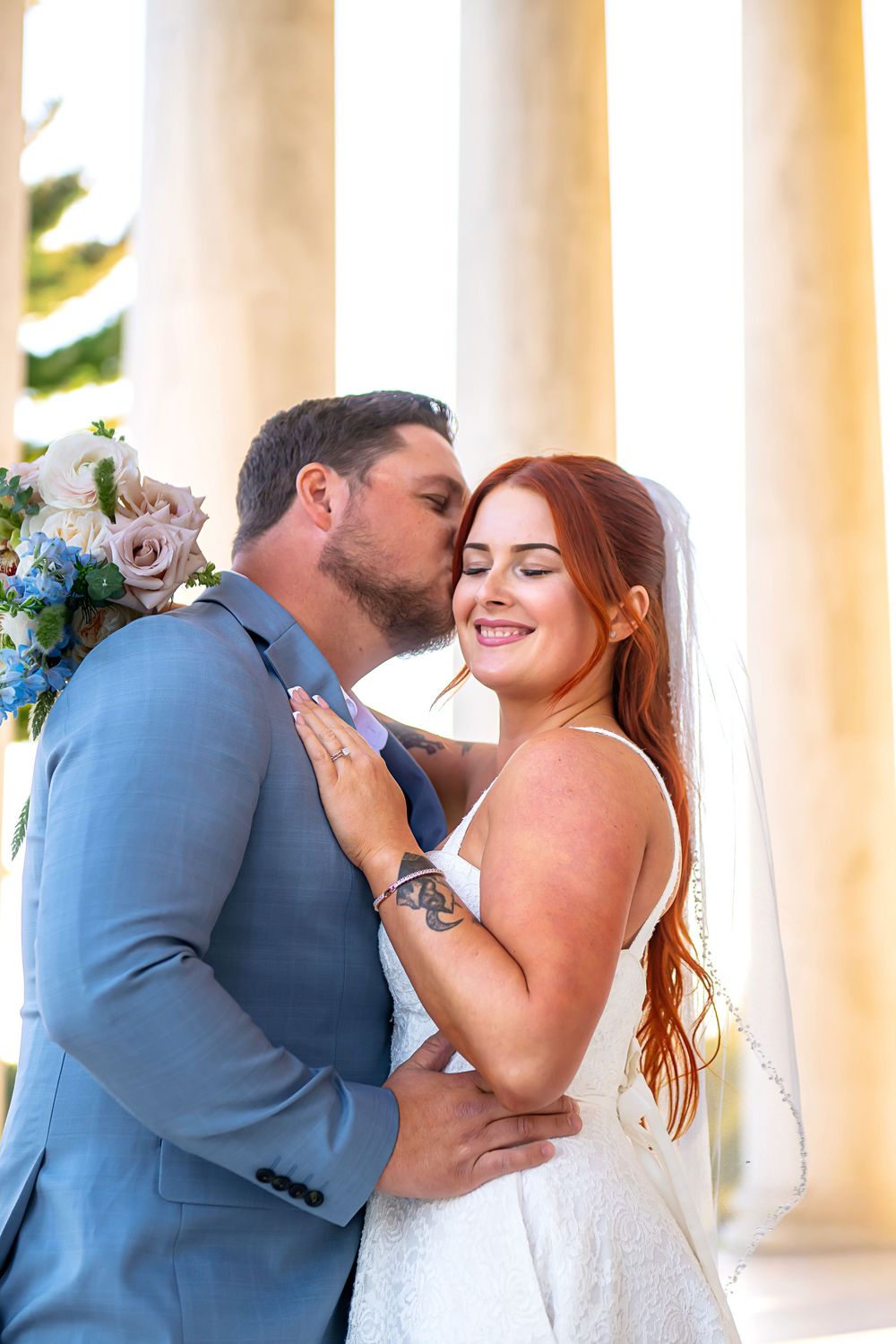 A romantic wedding photo sequence showing a couple sharing tender moments between white pillars with blue flowers.