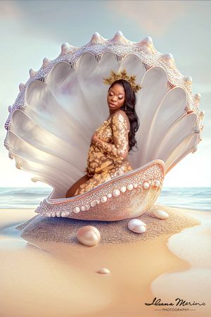 Pregnant woman wearing gold crown sits inside giant decorative seashell on sandy beach.