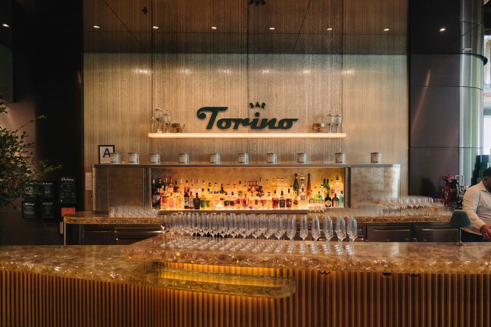 Elegant bar setup at Tamino with backlit bottles and glassware display.