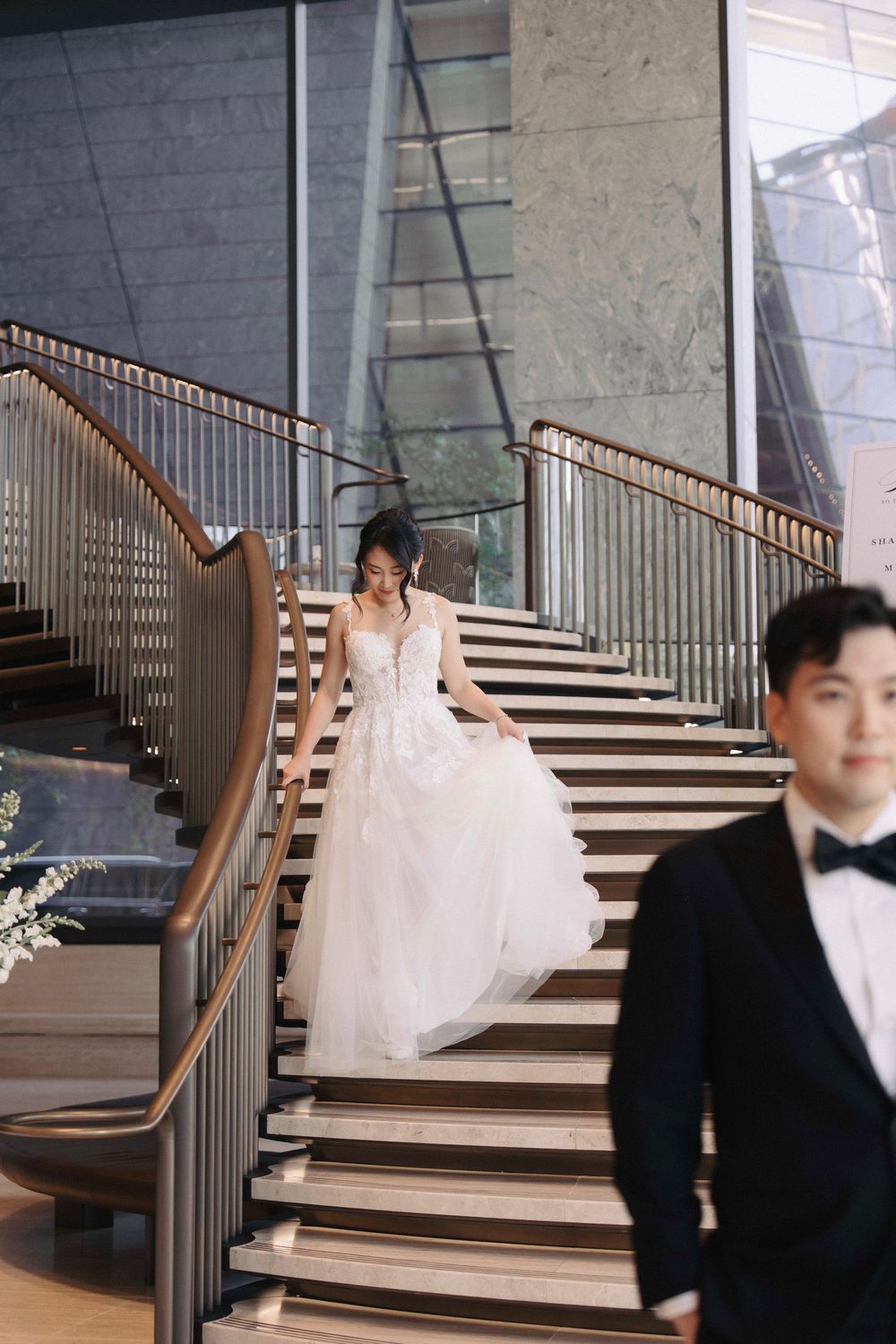 Elegant wedding photoshoot on modern staircase with architectural details.