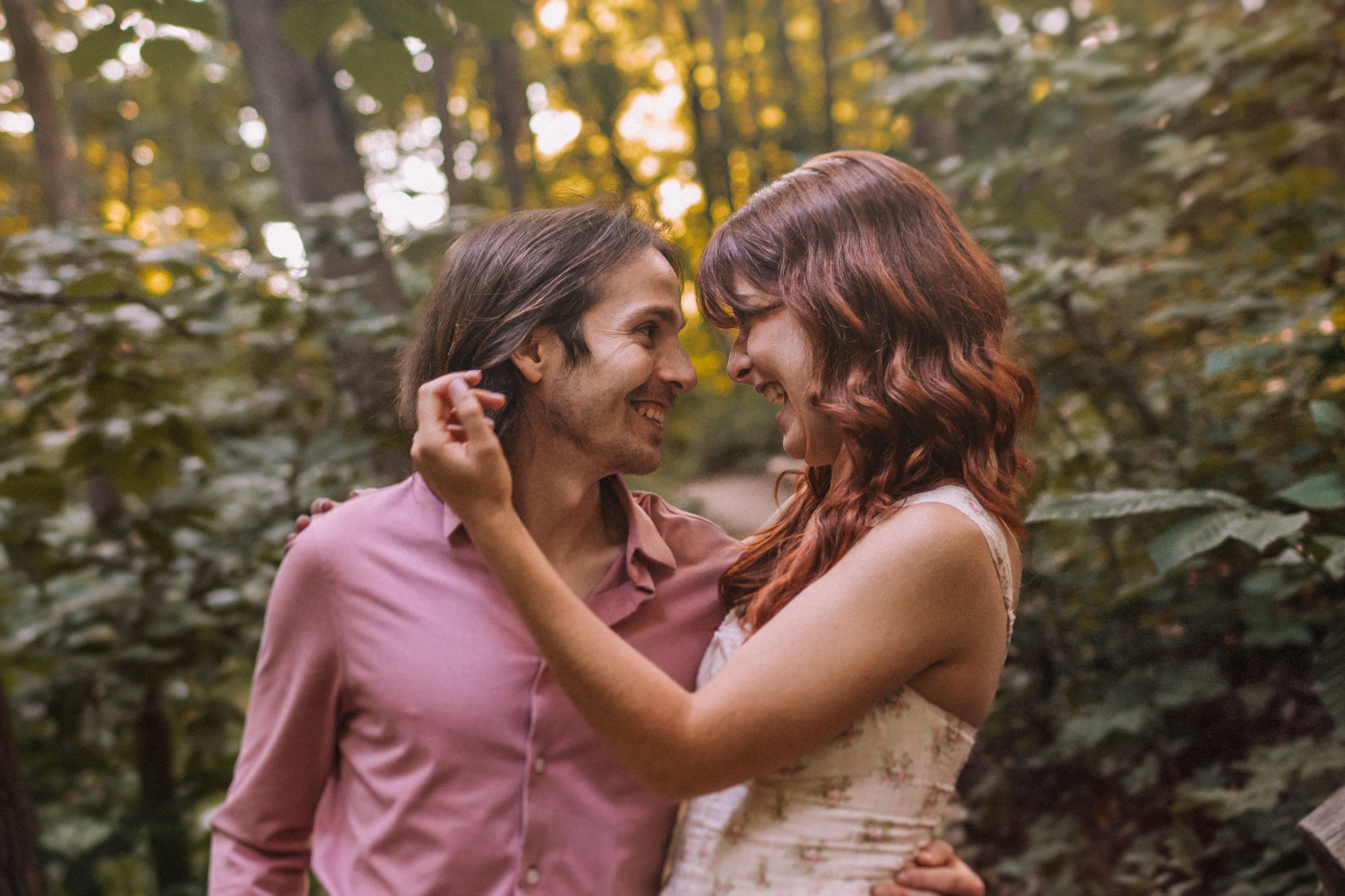 Romantic couple sharing joyful moment during golden hour photo session.
