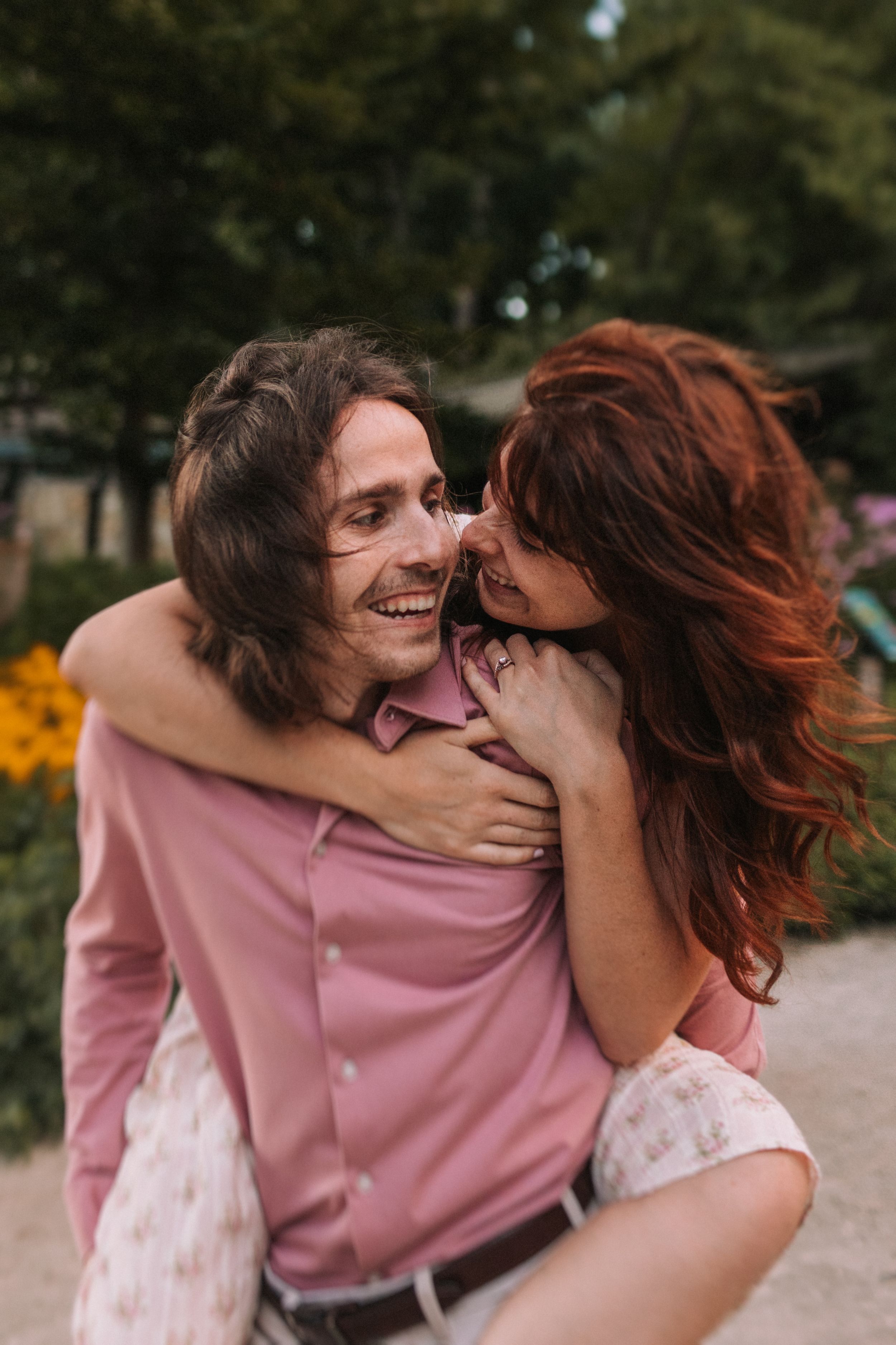 A couple shares a joyful embrace and laugh together outdoors in a candid photo series.
