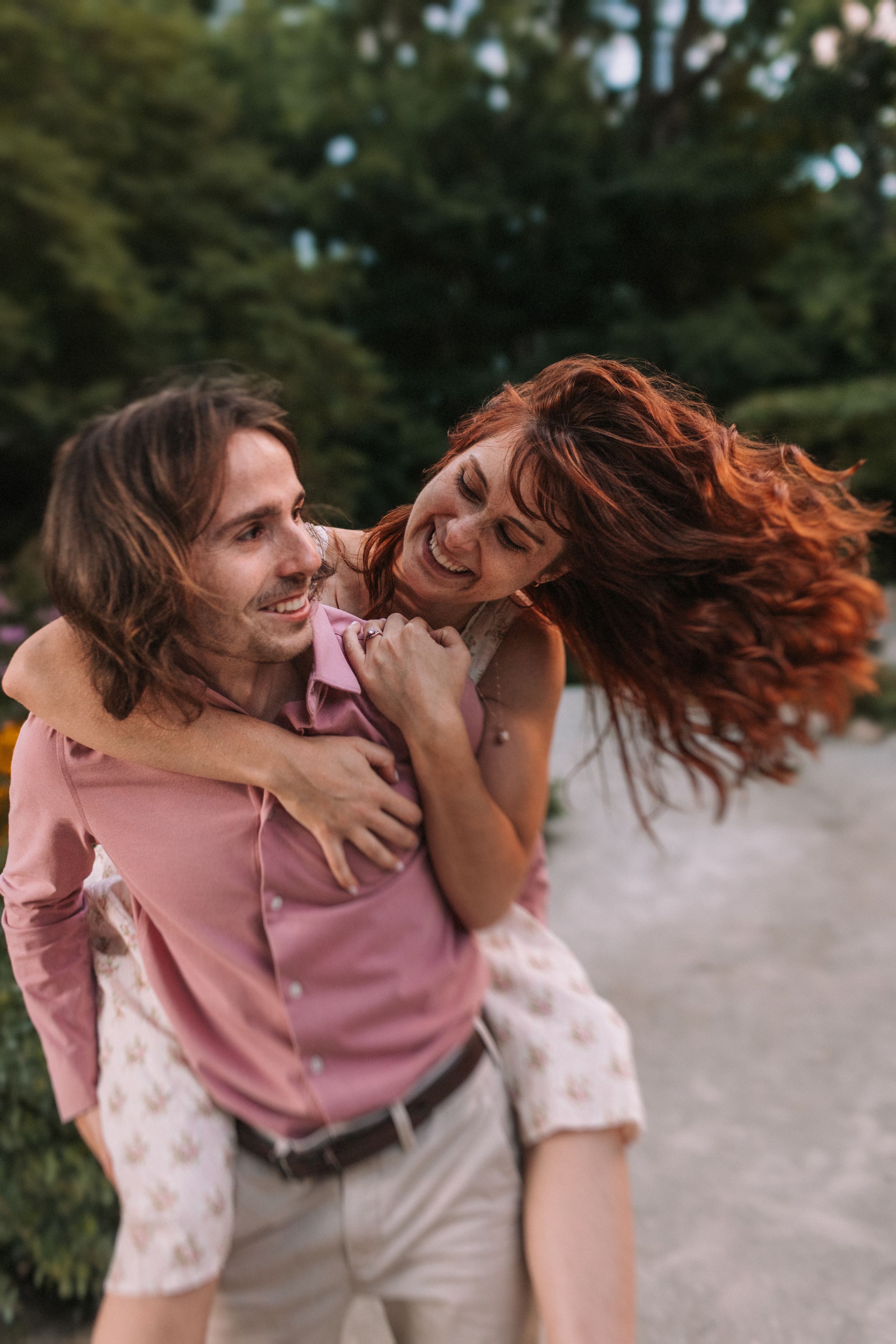 A joyful piggyback ride moment captured outdoors in matching pink and floral outfits.