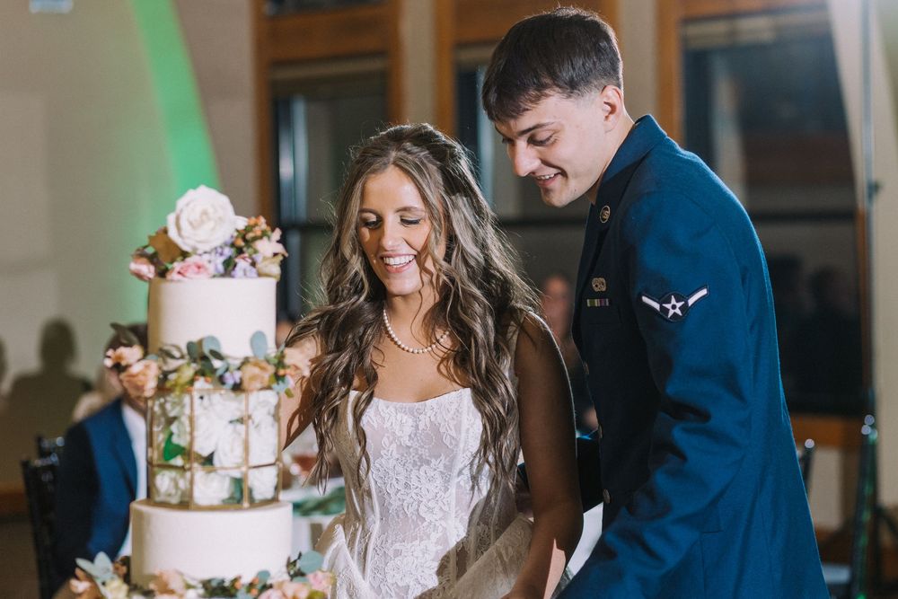 A couple shares their first dance at a wedding reception in an elegant ballroom with soft lighting.