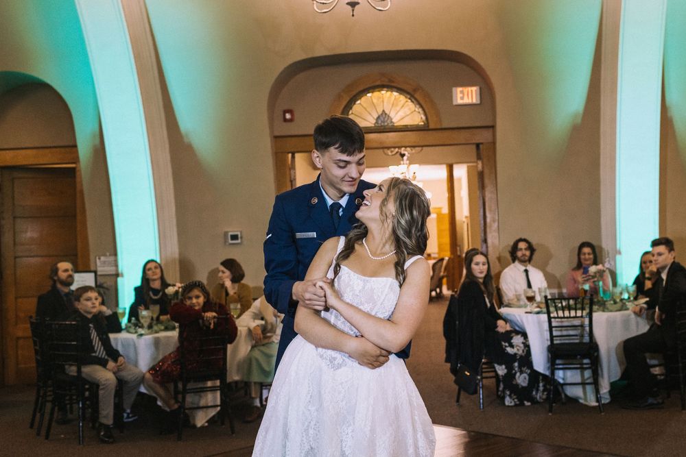 Wedding reception dance floor with teal uplighting and elegant decor.