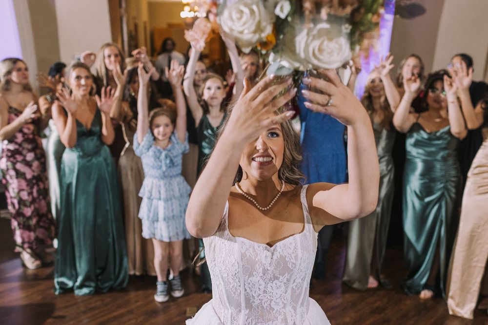 Wedding guests cheer and celebrate during a lively reception party.