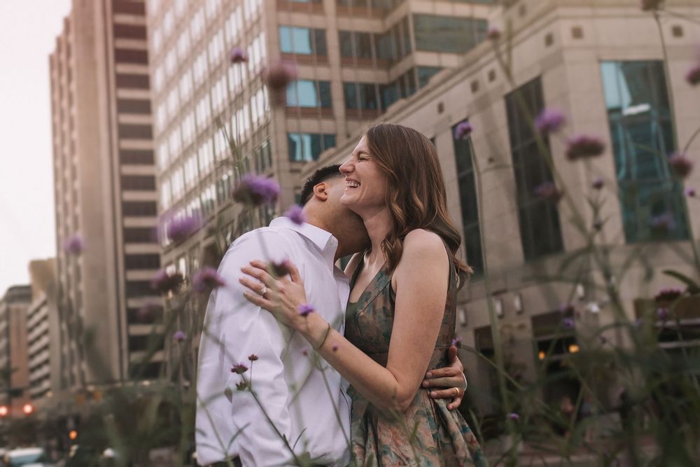 Couple sharing intimate moments during sunset photoshoot in downtown setting.