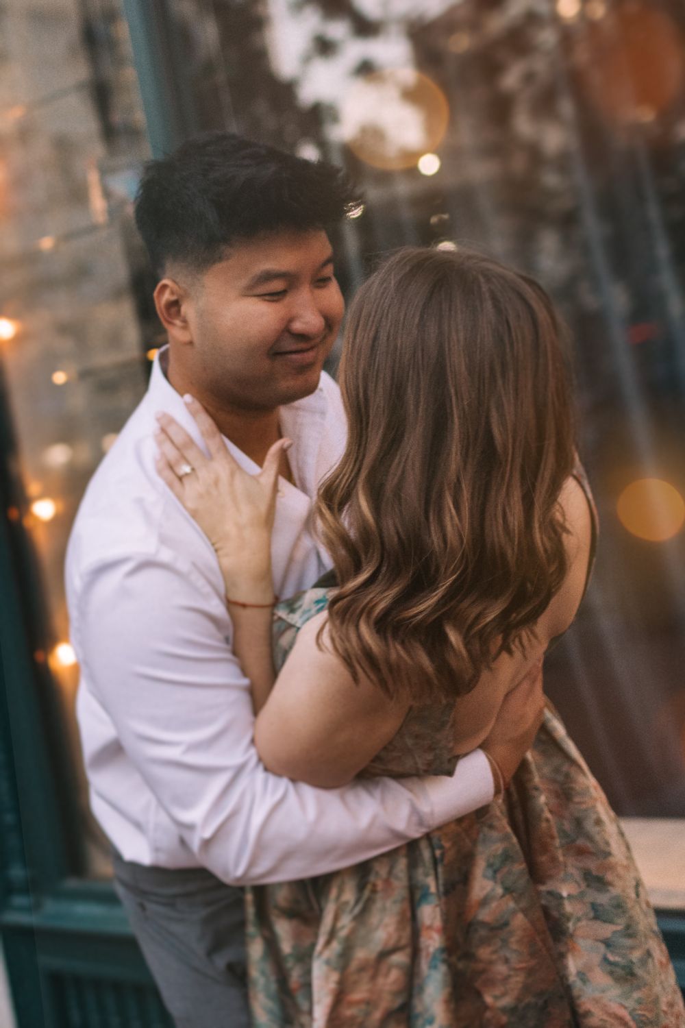 Intimate couple embraces and smiles during golden hour photo session.