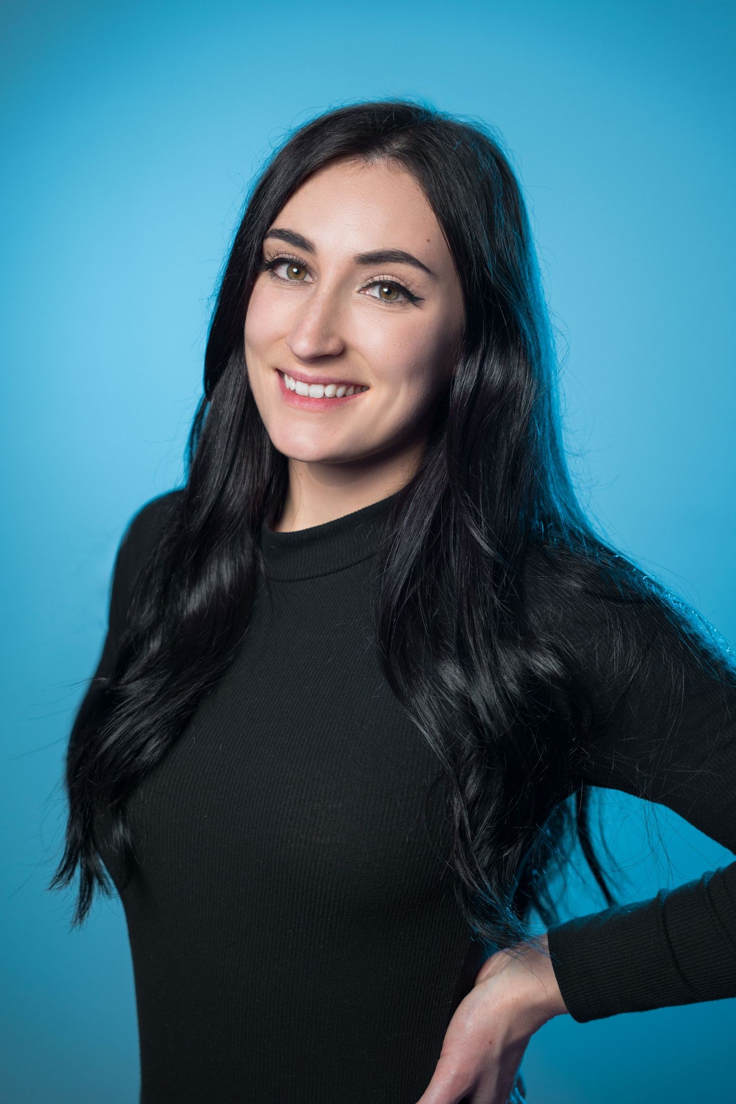 Professional branding headshot of a woman against a blue studio background.