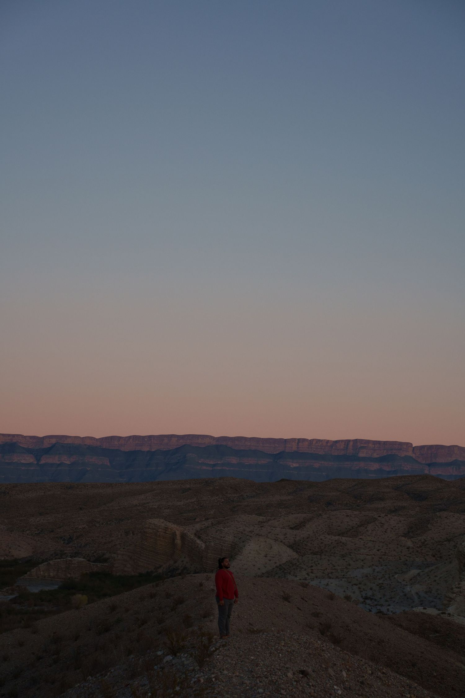 A series of desert landscape photos showing rocky terrain and distant cliffs at sunset with a person in red on the trail.