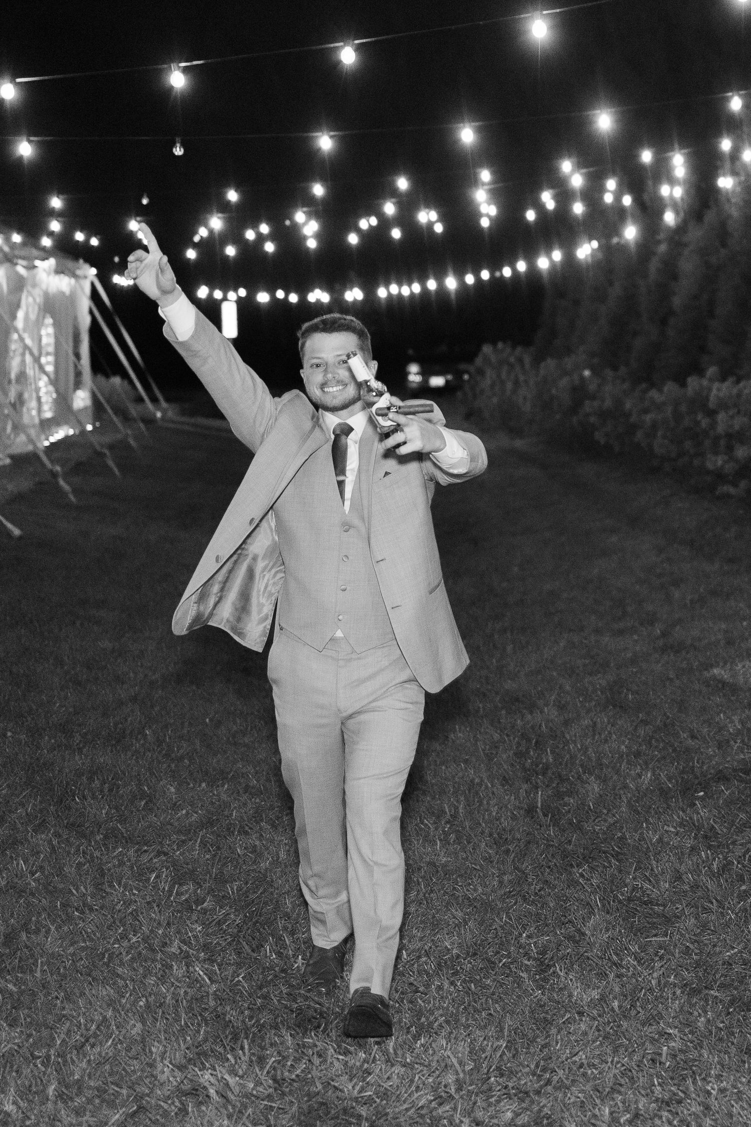Three black and white photos show a person dancing under string lights at an outdoor evening celebration.