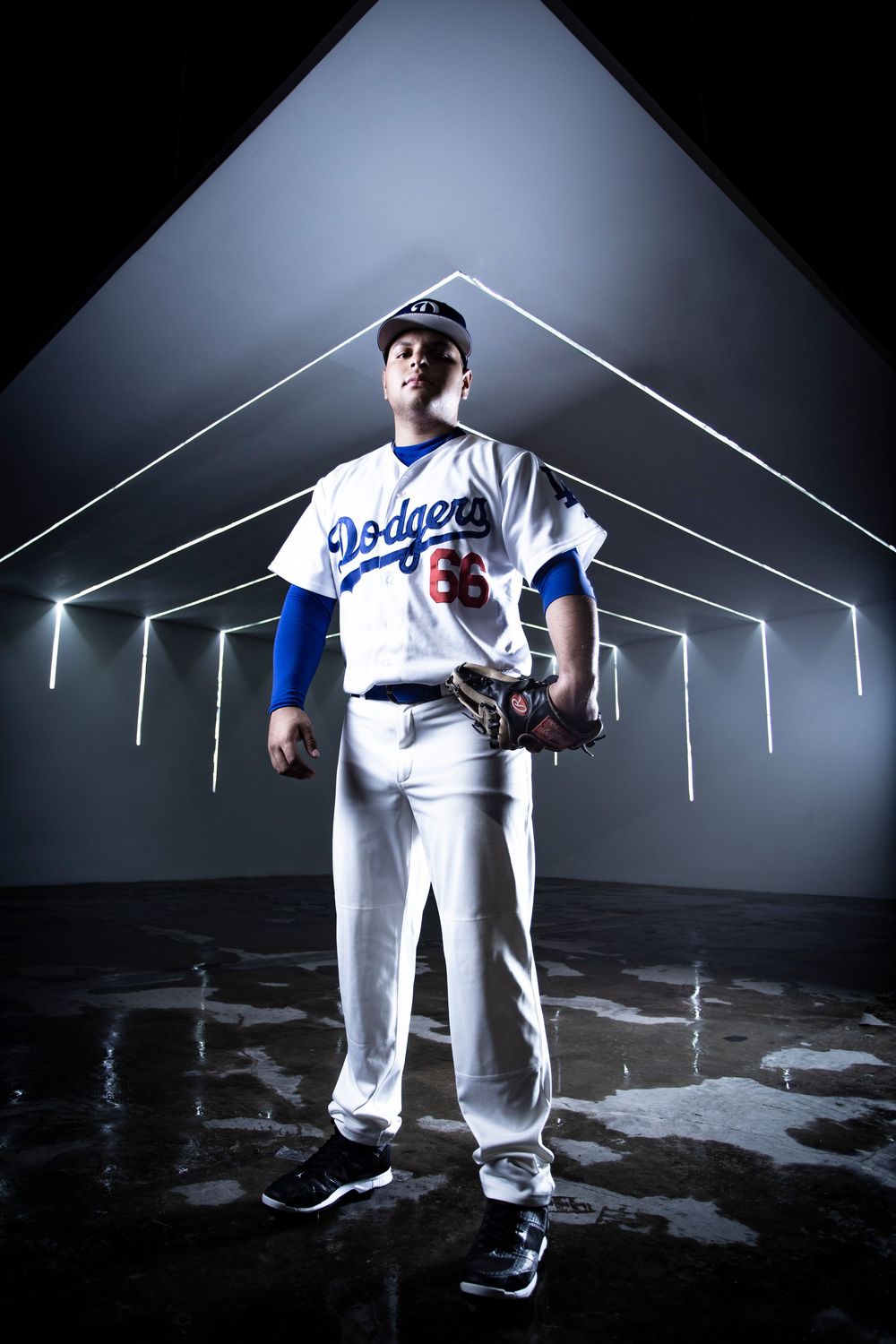 Dramatic studio photos of a Los Angeles Dodgers baseball player in uniform against dark background with white lighting.