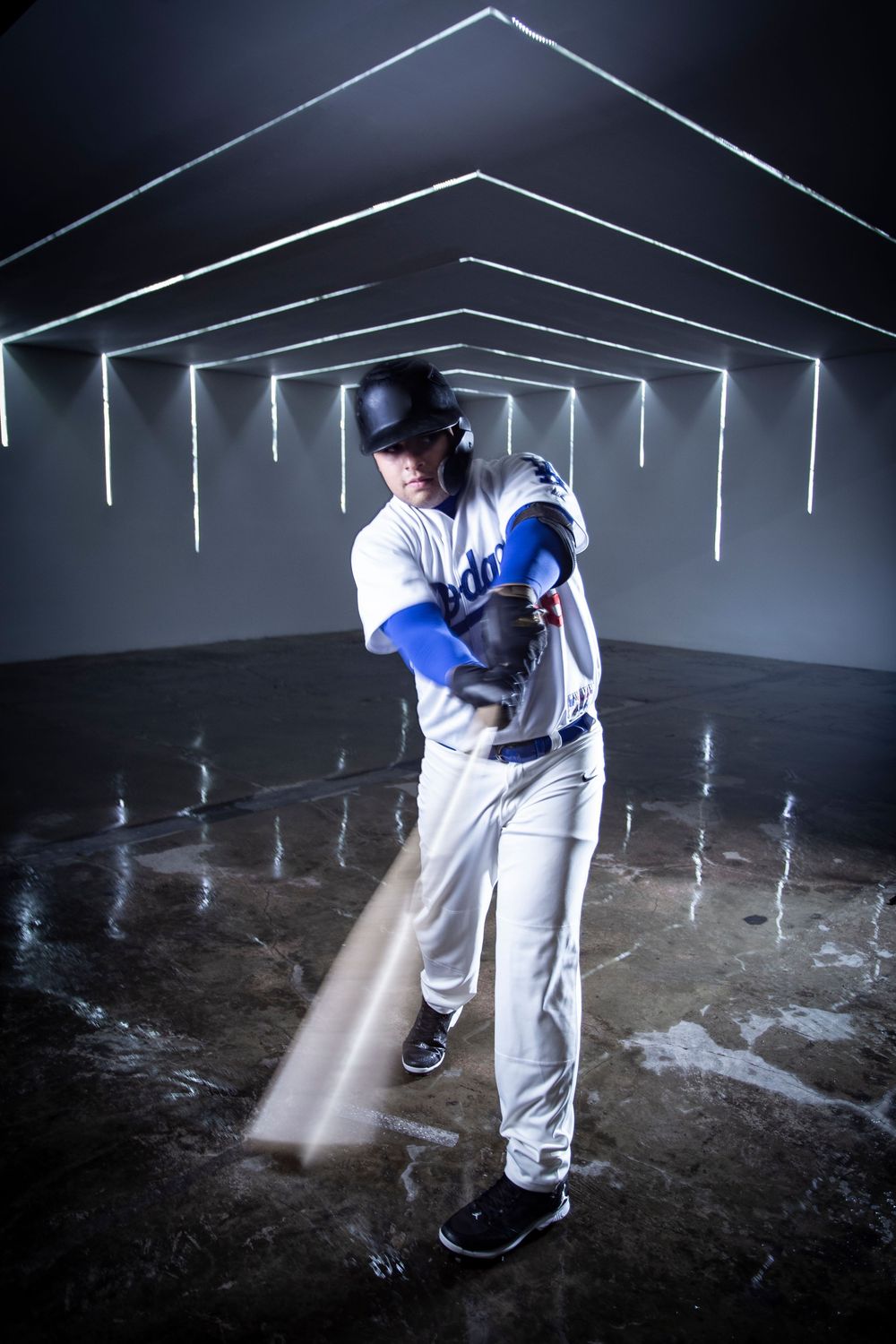 Baseball player in white uniform swings bat in dramatic lighting sequence showing motion blur and multiple positions.