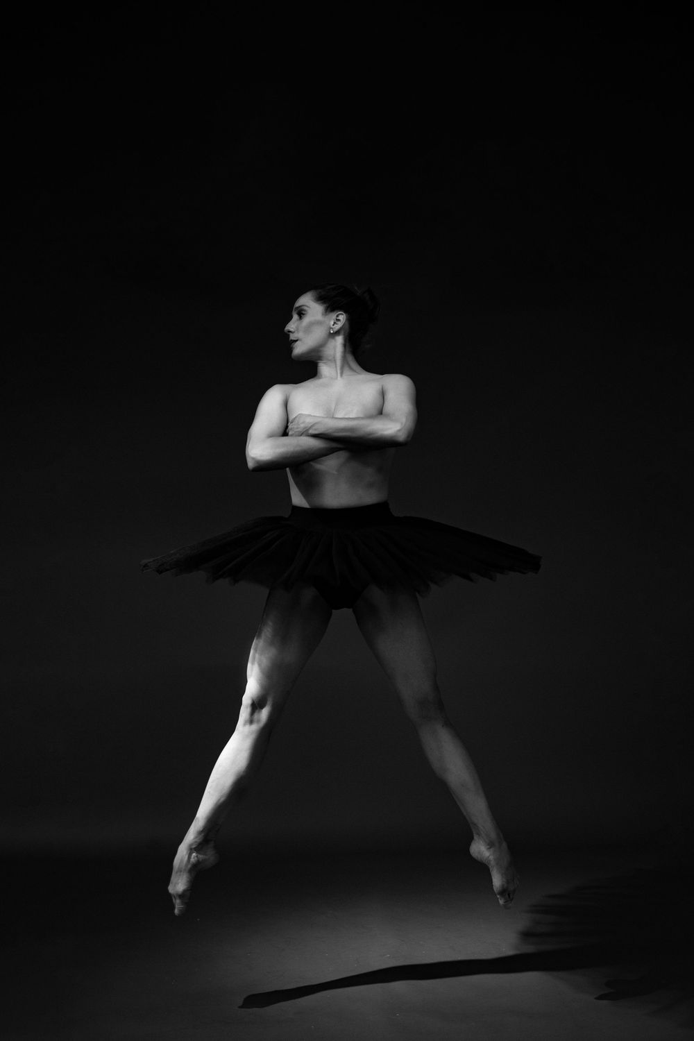 A dramatic black and white photo series captures a ballet dancer performing dynamic leaps and movements in silhouette.