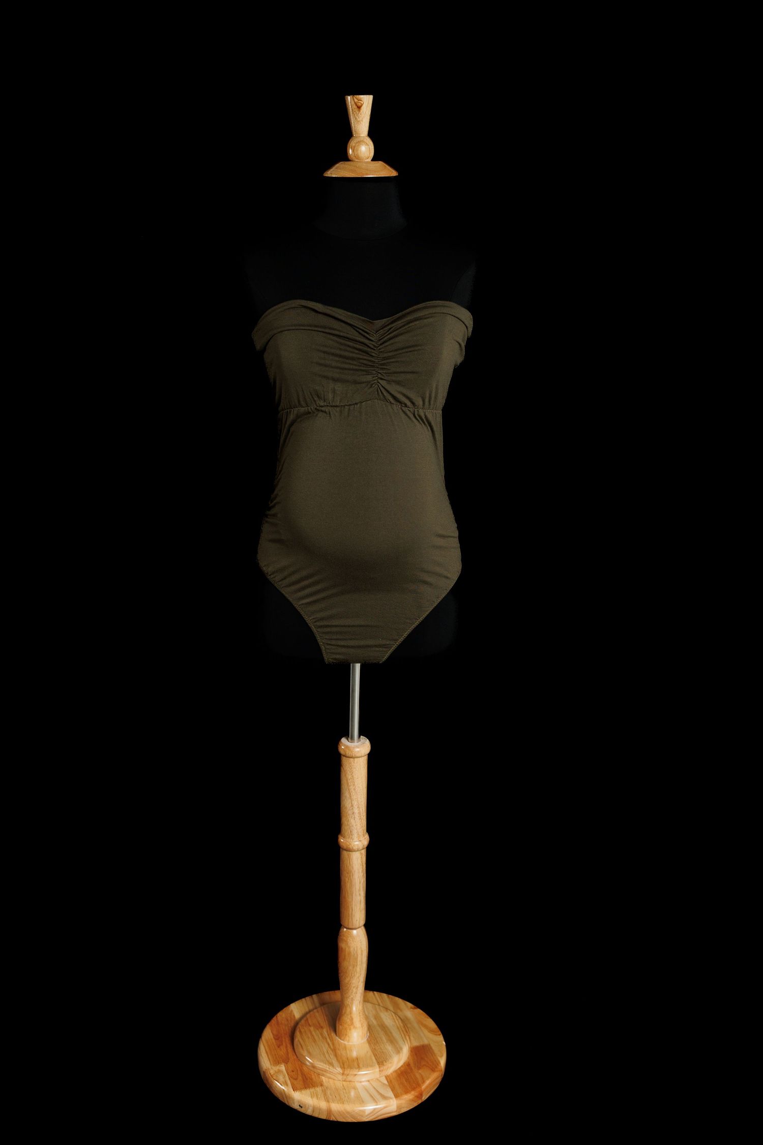 Olive green strapless maternity bodysuit with ruched bust detail and fitted silhouette displayed on a dress form.