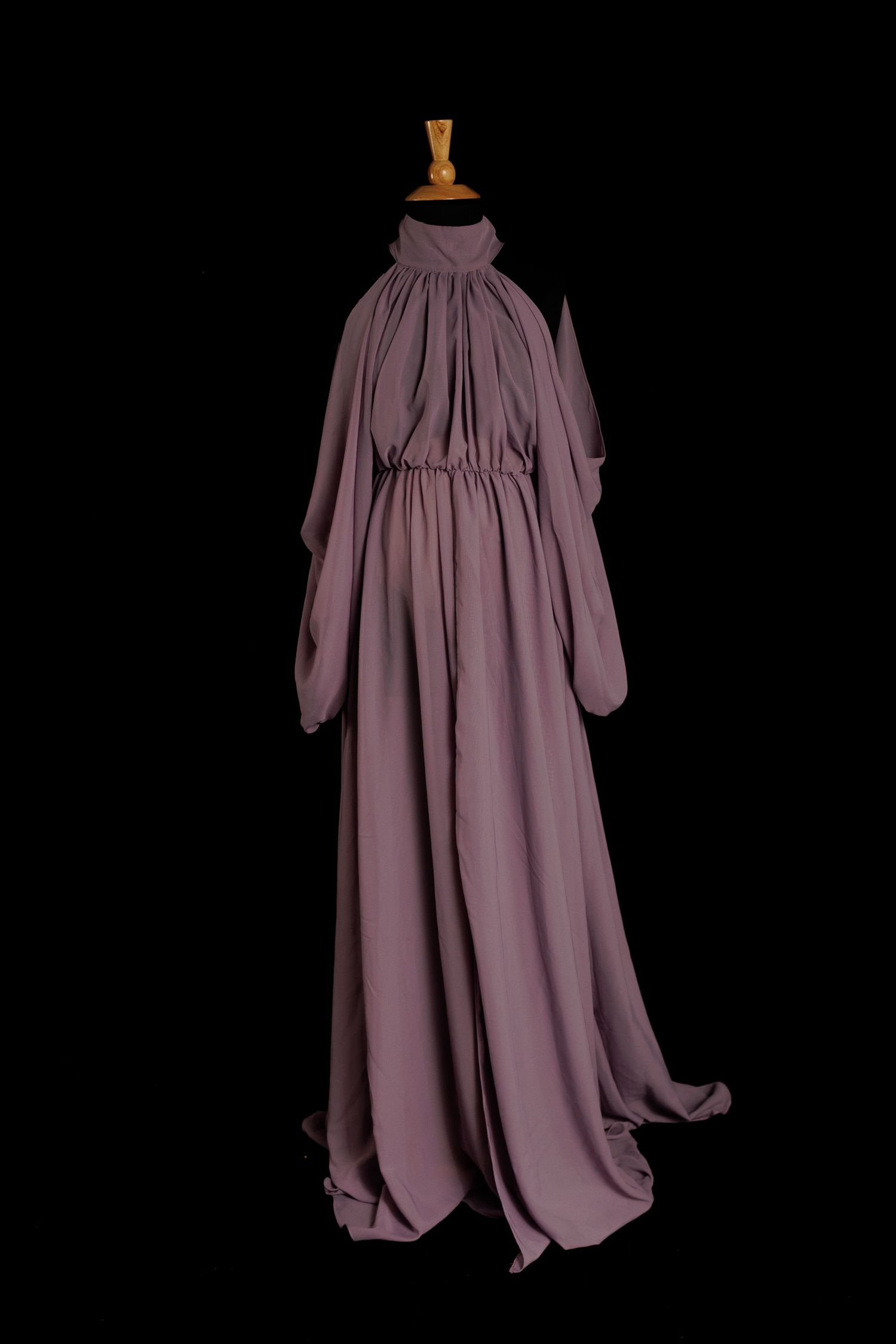 Purple chiffon maternity gown with high neckline, long sleeves, and flowing floor-length skirt on mannequin