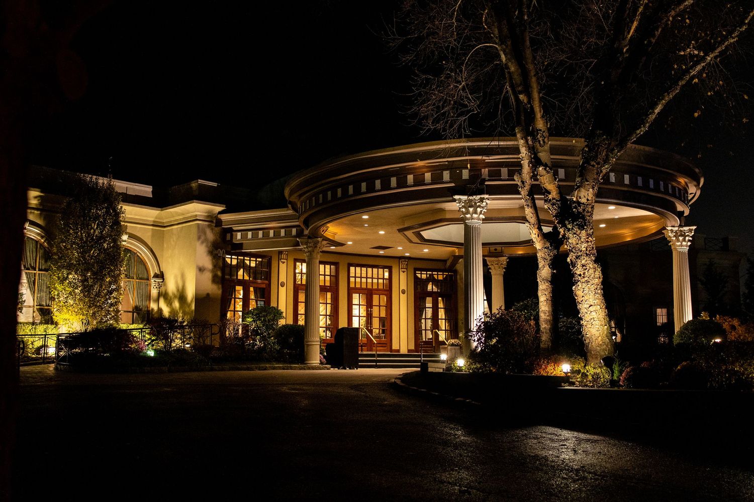 Illuminated curved building exterior with glowing windows and architectural lighting creates dramatic nighttime ambiance.