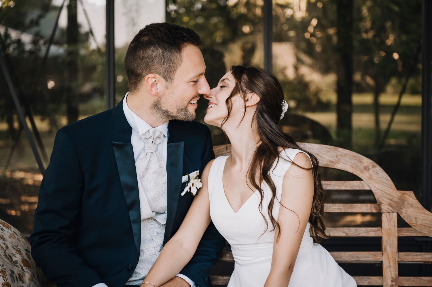 Una coppia romantica condivide momenti intimi su una panchina di legno rustica in un parco durante l'ora dorata.